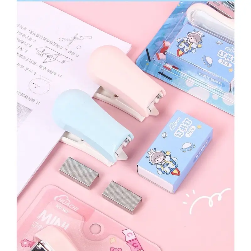 Dập ghim mini học sinh cute Dập ghim mini màu hồng và xanh pastel đặt trên vở học sinh
