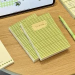 Cặp sổ ghi chép takenote nhanh caro xanh lá cây bên cạnh bút
