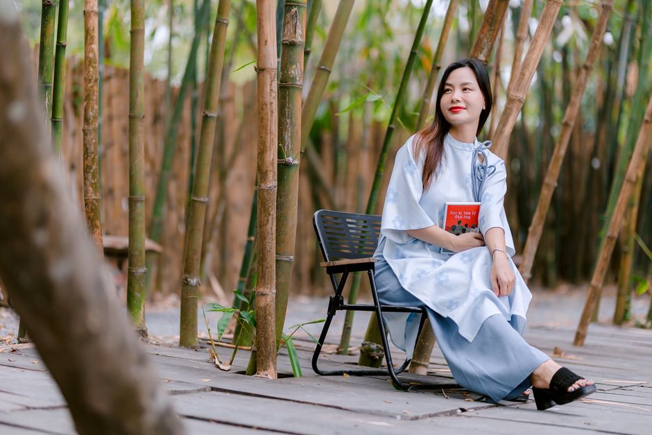 Người phụ nữ ngồi đọc sách thư thái trong vườn tre Tránh ảo tưởng kiến thức bằng cách thấu hiểu sâu sắc nội dung sách