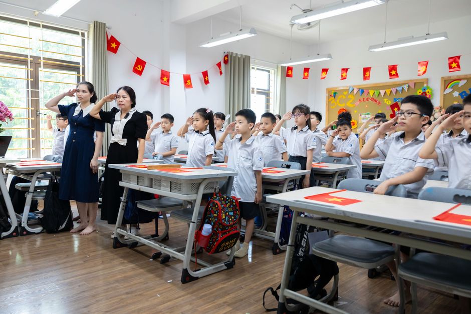 Học sinh tiểu học nghiêm túc chào cờ trong lớp học Học sinh tiểu học rèn luyện động lực học tập nội tại tại trường lớp